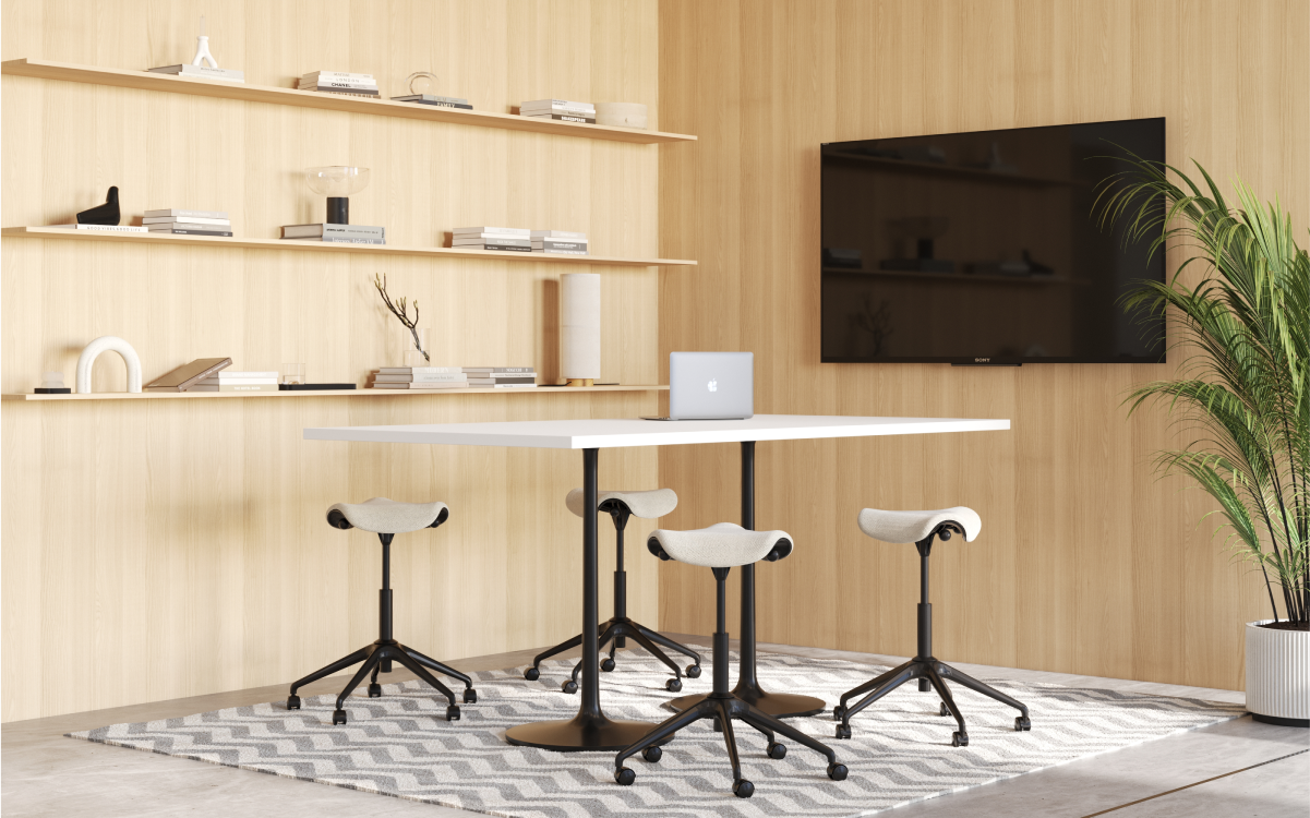 Modern office setup with a table, Humanscale Saddle Stool, and shelves against a wooden wall. Kansas City Office Design.