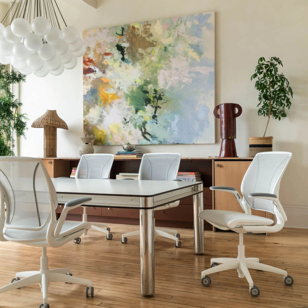 Modern office setup with a glass conference table and Humanscale World task chairs in white mesh with white frame. Kansas City Office Design.