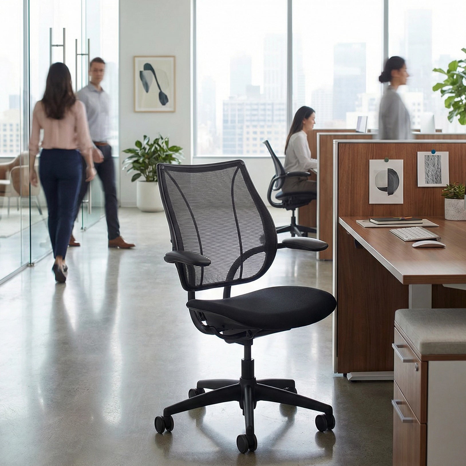 Black office chair in an office setting with people and desks in the background. Kansas City Office Design.