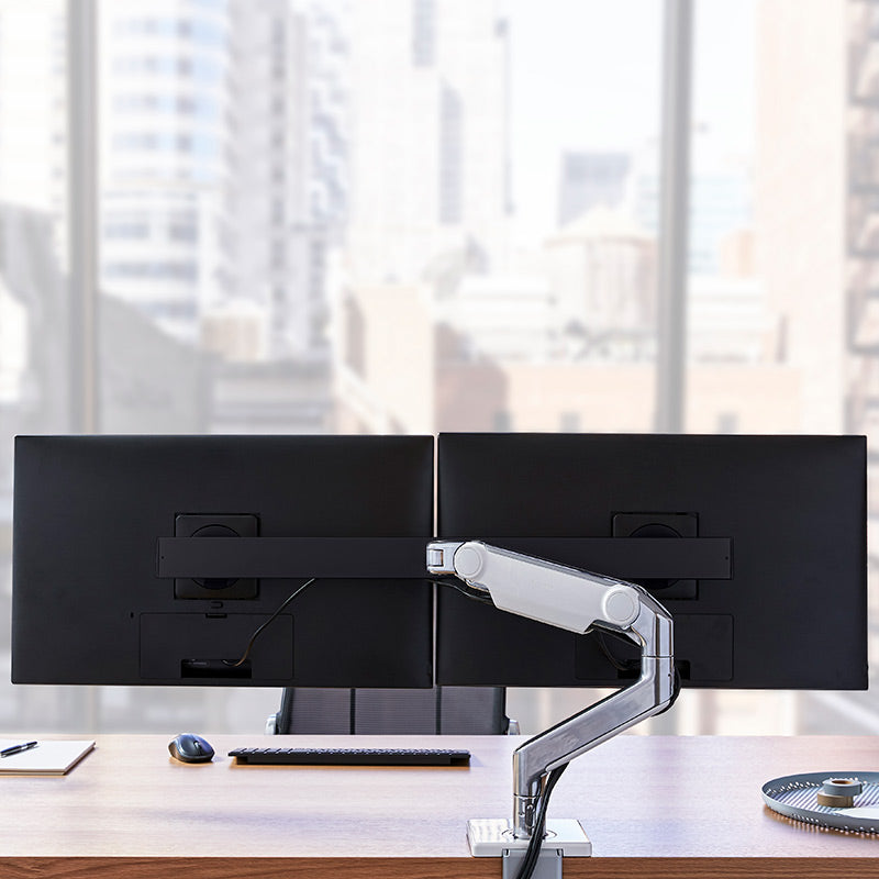 Humanscale M8.1 Dual monitor arm installed in modern office workstation