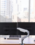 Humanscale M8.1 Dual monitor arm installed in modern office workstation