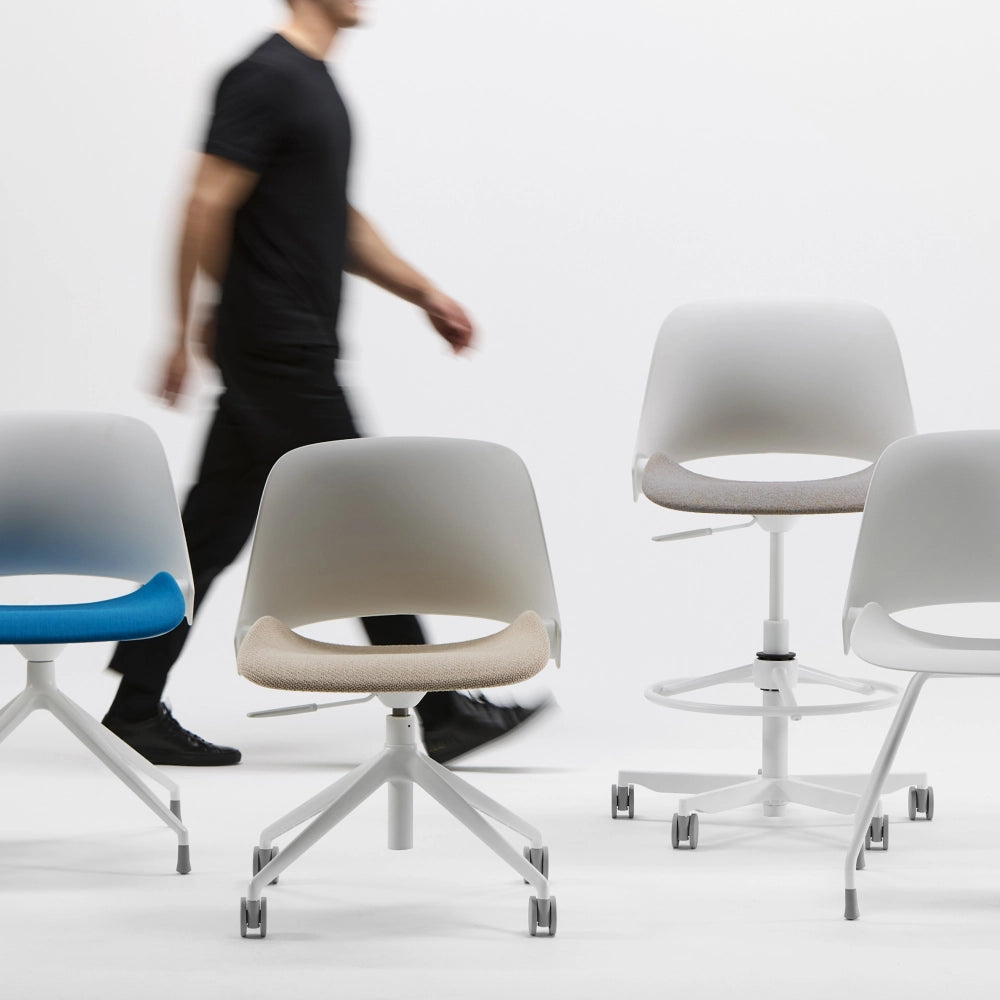 Humanscale Tre office chairs, stools and guest chairs with a person walking in the background. Kansas City Office Design.