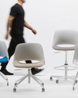 Humanscale Tre office chairs, stools and guest chairs with a person walking in the background. Kansas City Office Design.