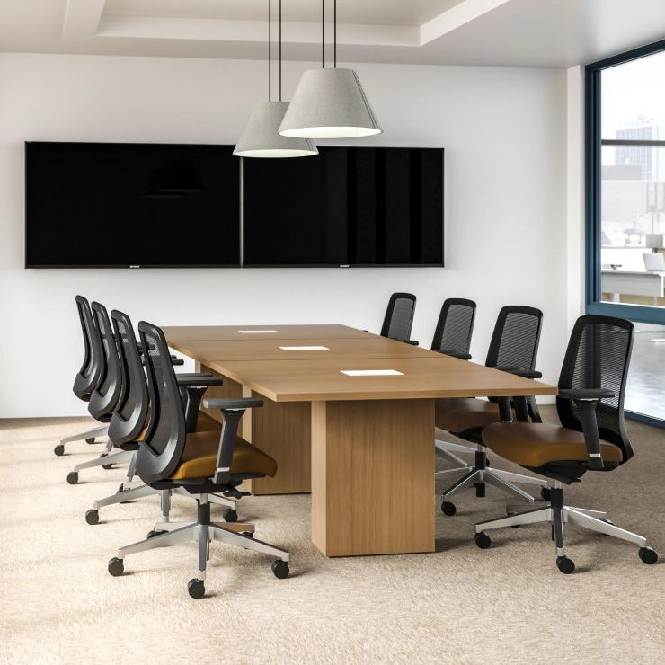 Modern conference room with a long wooden table and black office chairs. Kansas City Office Design.