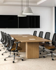 Modern conference room with a long wooden table and black office chairs. Kansas City Office Design.