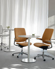 Modern office chairs and Humanscale Float Gather 30" round tables in a bright room with white curtains. Kansas City Office Design.