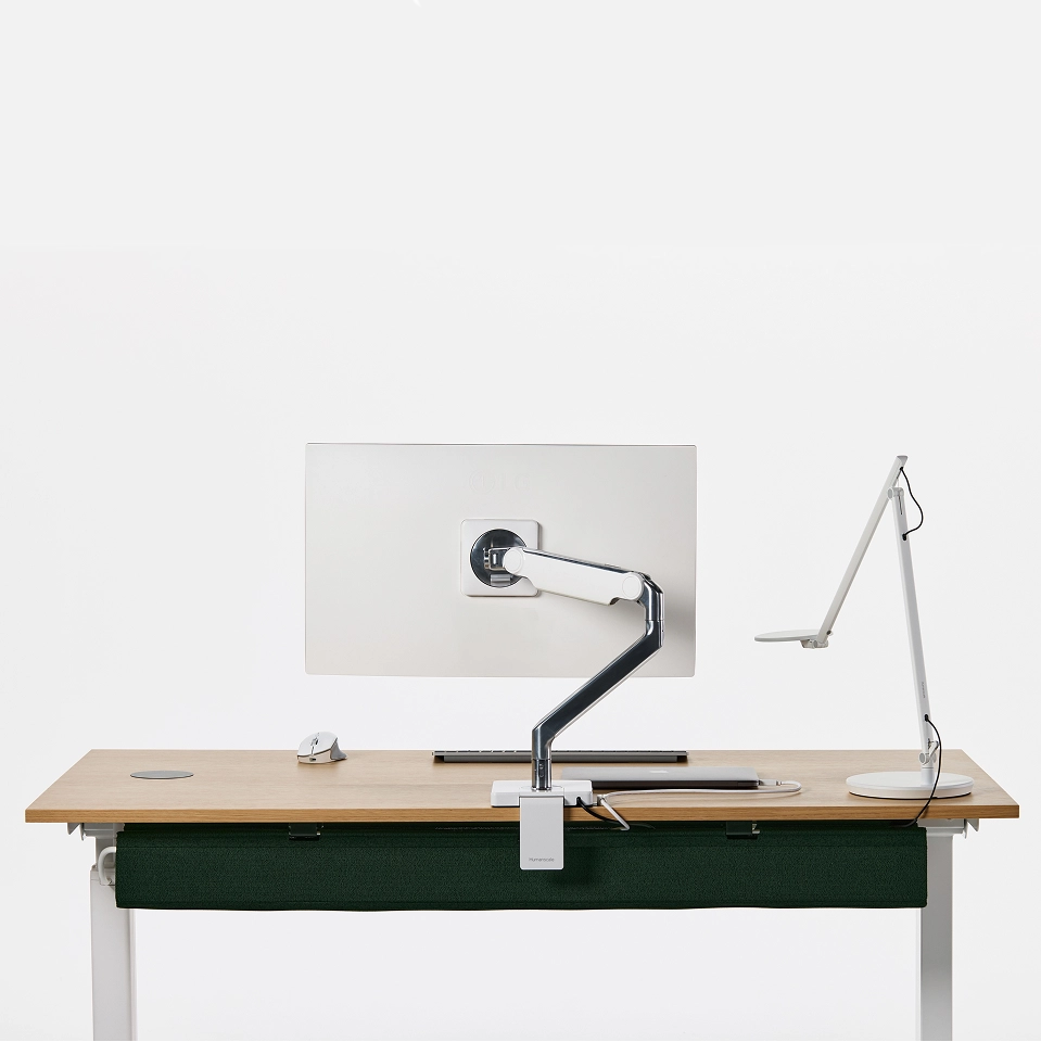 Modern office desk setup with a Humanscale NeatTech cable management installed under the top. It also includes a monitor, keyboard, and lamp on a white background. Kansas City Office Furniture.