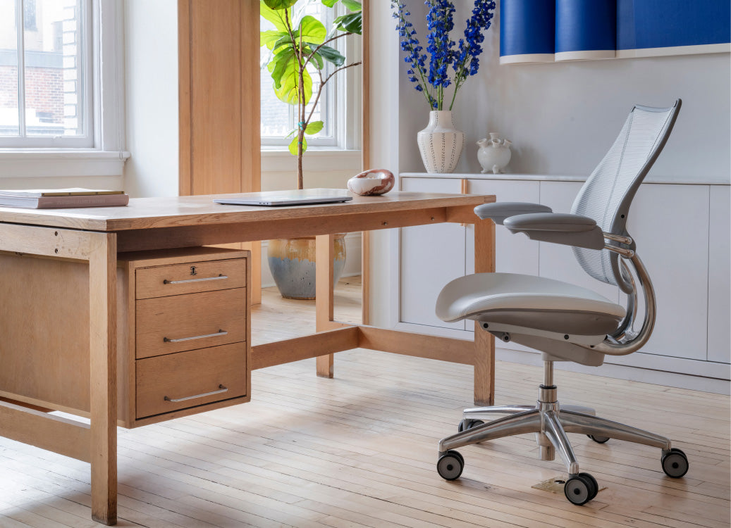 Wooden desk with a Humanscale Liberty chair in a bright office setting. Kansas City Office Design.