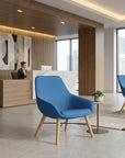 Modern office lobby with blue chairs, reception desk, and city view. Kansas City Office Design.