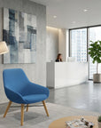 Modern office interior with a blue chair, abstract art, and a reception desk. Kansas City Office Design.