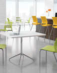 Modern office space with green and yellow chairs around white tables. Kansas City Office Design.