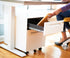 Person placing a book into a mobile pedestal from SitOnIt Home collection under a height adjustable desk. Kansas City Office Furniture.