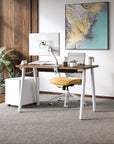 Modern office desk with chair, computer monitor, and decor in a well-lit room. Kansas City Office Design.