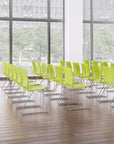Green chairs arranged in a modern office setting with large windows. Kansas City Office Design.