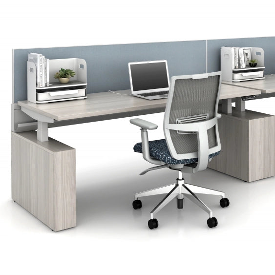 Modern office with power bench sit to stand desk setup with a chair, laptop, and printer in a minimalistic office. Kansas City Office Design.