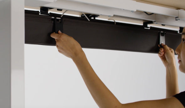 Person adjusting the HumanScale NeatTech Cable Management System. Kansas City Office Furniture