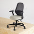 Ergonomic office chair with mesh backrest and beige seat on a wooden surface.
