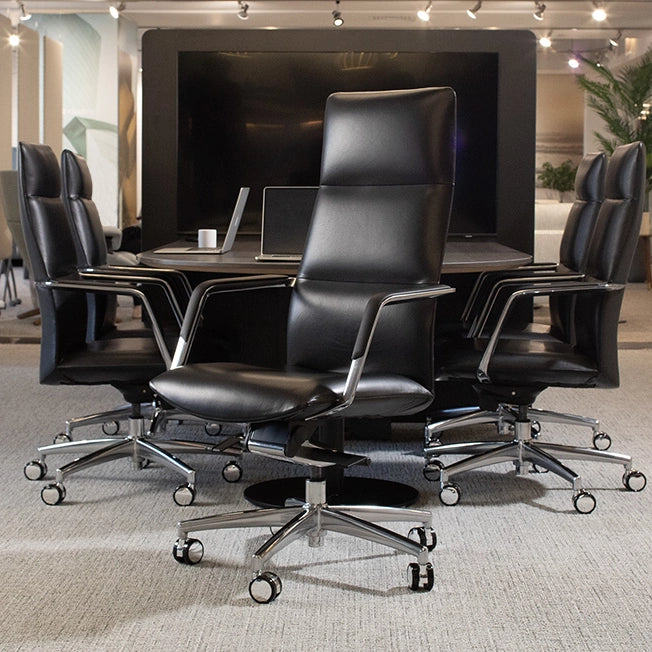Conference room with black leather chairs and a large screen in the background. Kansas City Office Design