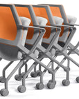 Row of modern office chairs with orange backrests and gray frames on a white background. Kansas City Office Design.