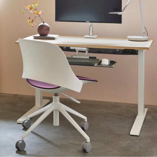 Modern office setup with a adjustable desk, chair, and computer equipment. Kansas City Office Design