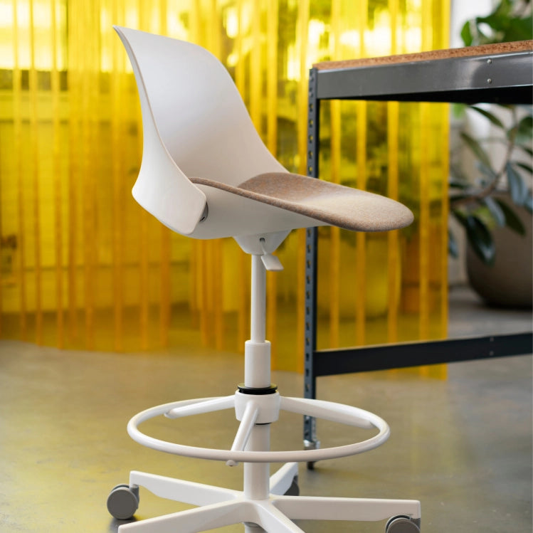 White office chair with a yellow curtain in the background. Kansas City Office Design